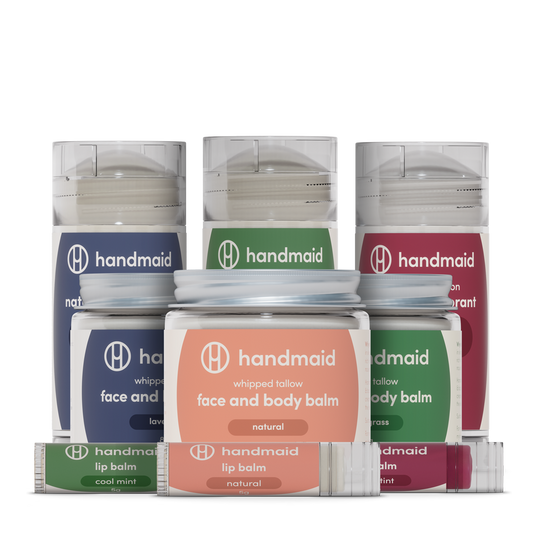 A collection of 'Handmaid' brand skin care products including whipped tallow balms and lip balms in various scent options.