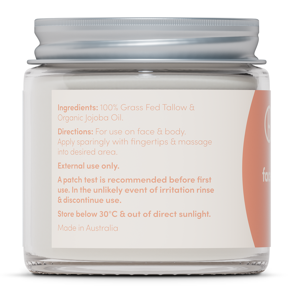 A close-up of a skincare glass jar label showing the product ingredients, which include 100% grass-fed tallow and organic jojoba oil, along with directions for face and body use.